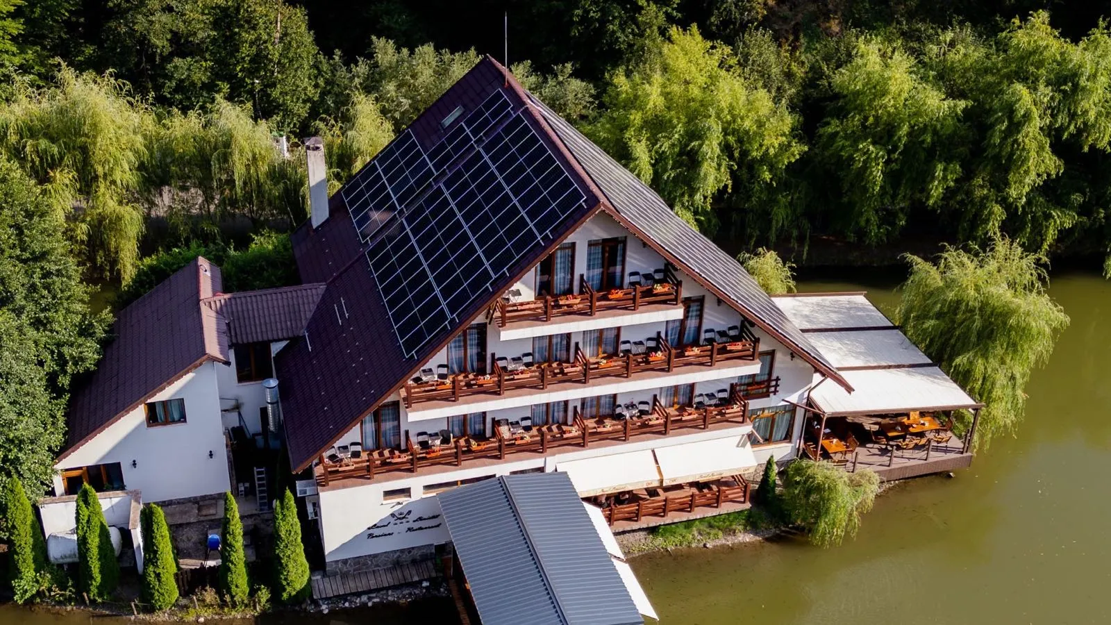 Pensiunea Lacul Liniștit Moneasa pe insula de pe lac cu podeț de lemn